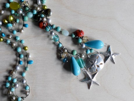 A close up of the silver cast starfish and sand dollar pendants by Steven Mehle.