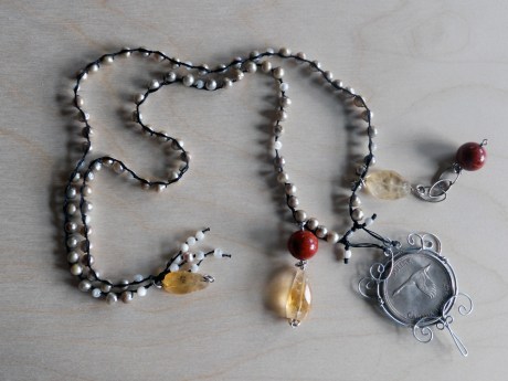 A second wire-caged coin (Canadian Centennial Dollar, 1967) by GJ with small champagne-coloured freshwater pearls and miscellaneous semi-precious stones.