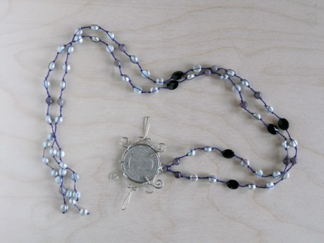 Wire-wrapped Canadian 1957 coin by GJ Pearson with silvery pearls, onyx and lepedolite. © Firehorse Designs 2013