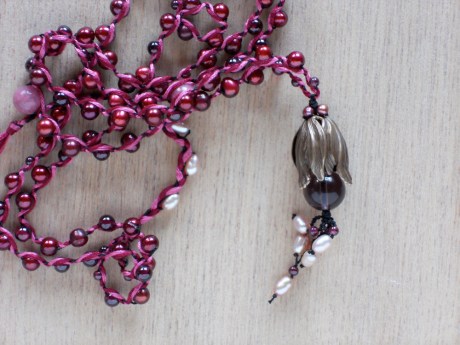 Detail. Pale pink freshwater pearls and tiny garnets are used in the floral detail.