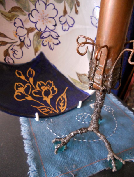 One of GJ's copper bud vases and a colourful plate rest on a small embroidered piece by Annie.