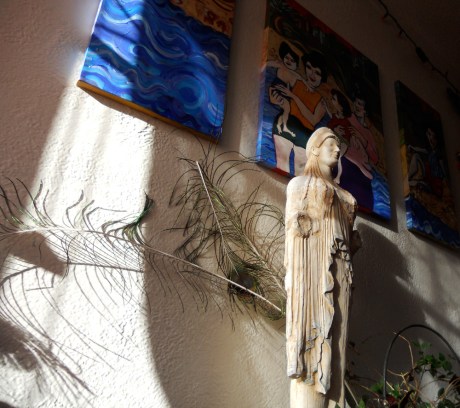 Sunlight and shadow magic with Annie's paintings and peacock feathers.