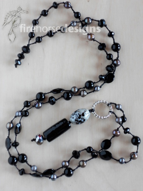 Black stones, grey pearls and glass.