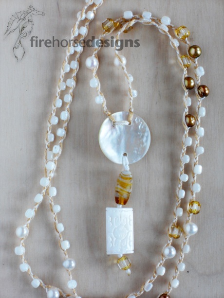 Mother of pearl, gold-coloured fresh-water pearls and glass.